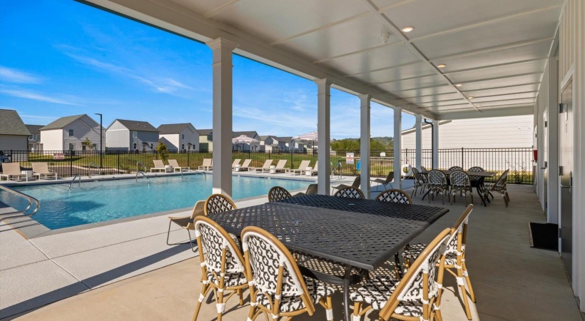 a pool with chairs and tables by it